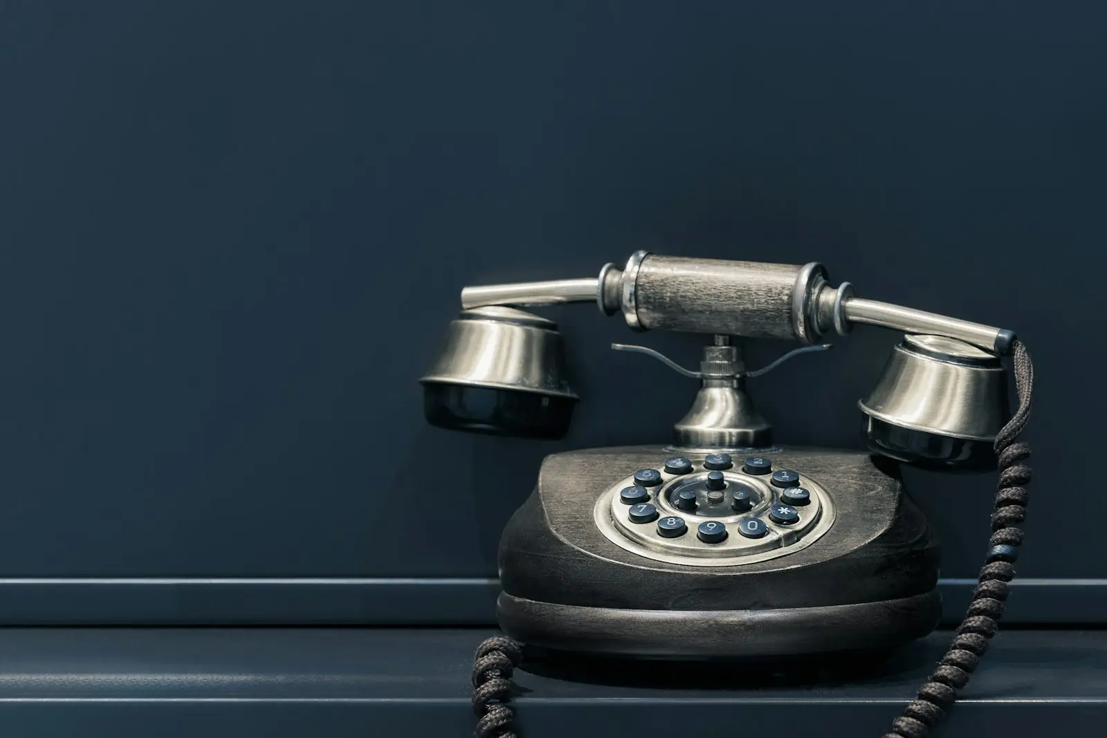 Téléphone ancien à cadran posé sur une étagère