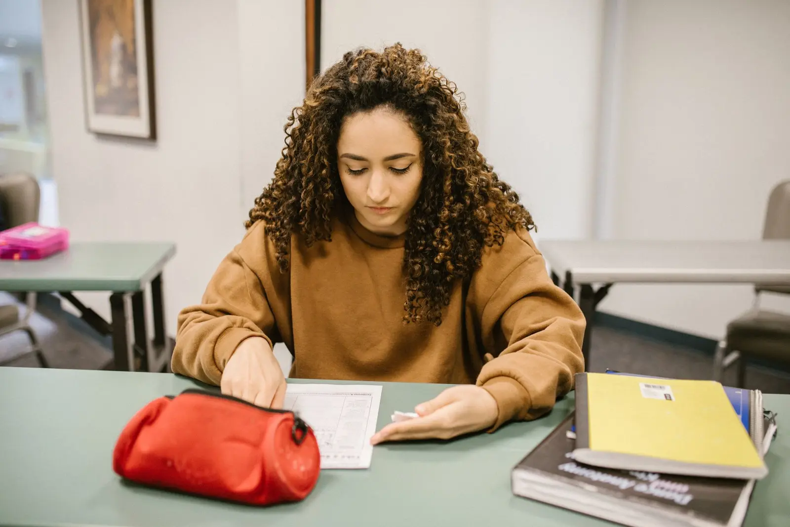 Étudiante qui révise un examen de langue avec ses cahiers