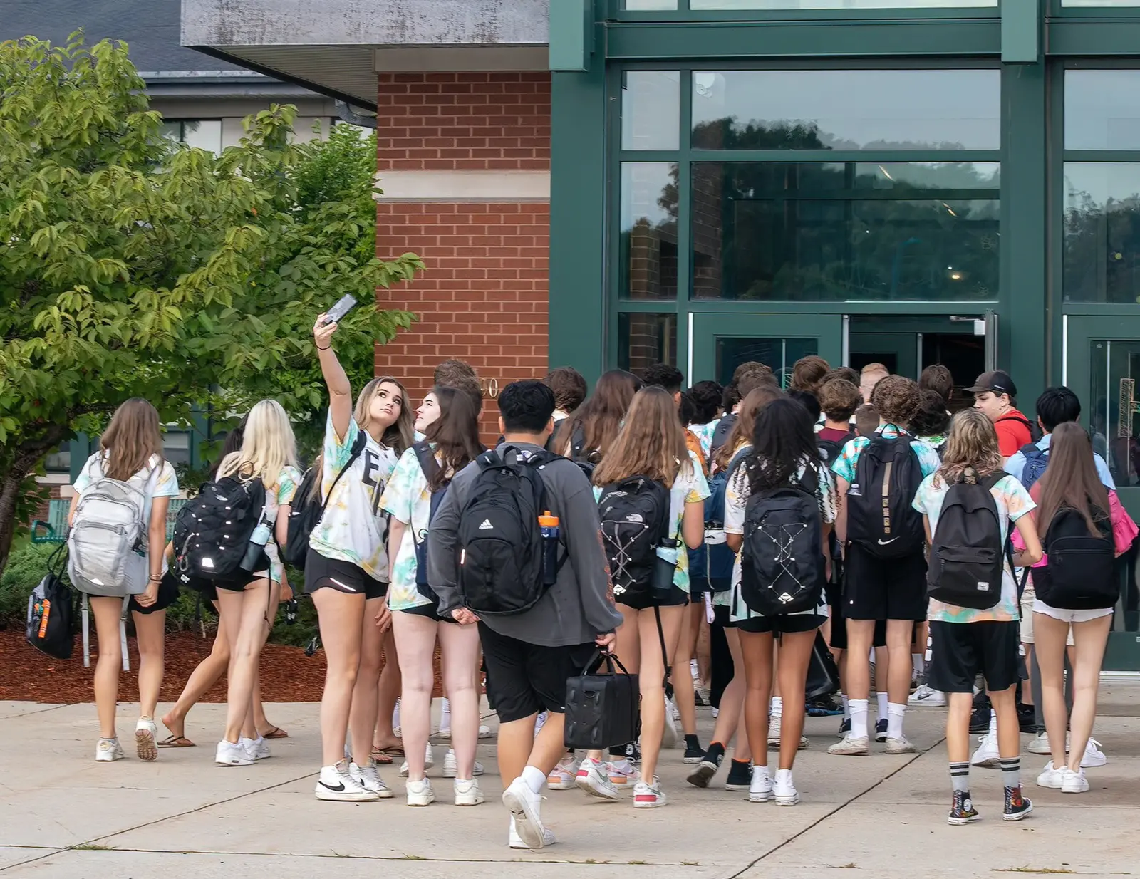 Groupe d’élèves sac au dos devant le lycée