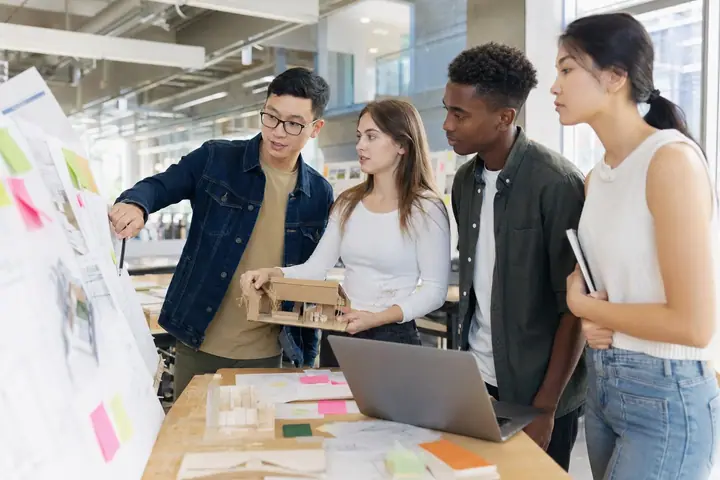 Étudiants collaborant sur un projet appliqué dans un espace de création universitaire