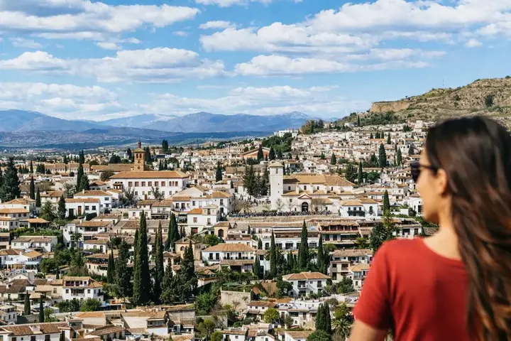 Vue sur les toits d'une ville andalouse, une femme de dos au premier plan