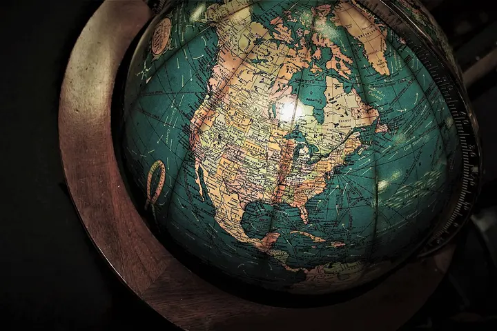 Globe terrestre ancien posé sur un socle en bois